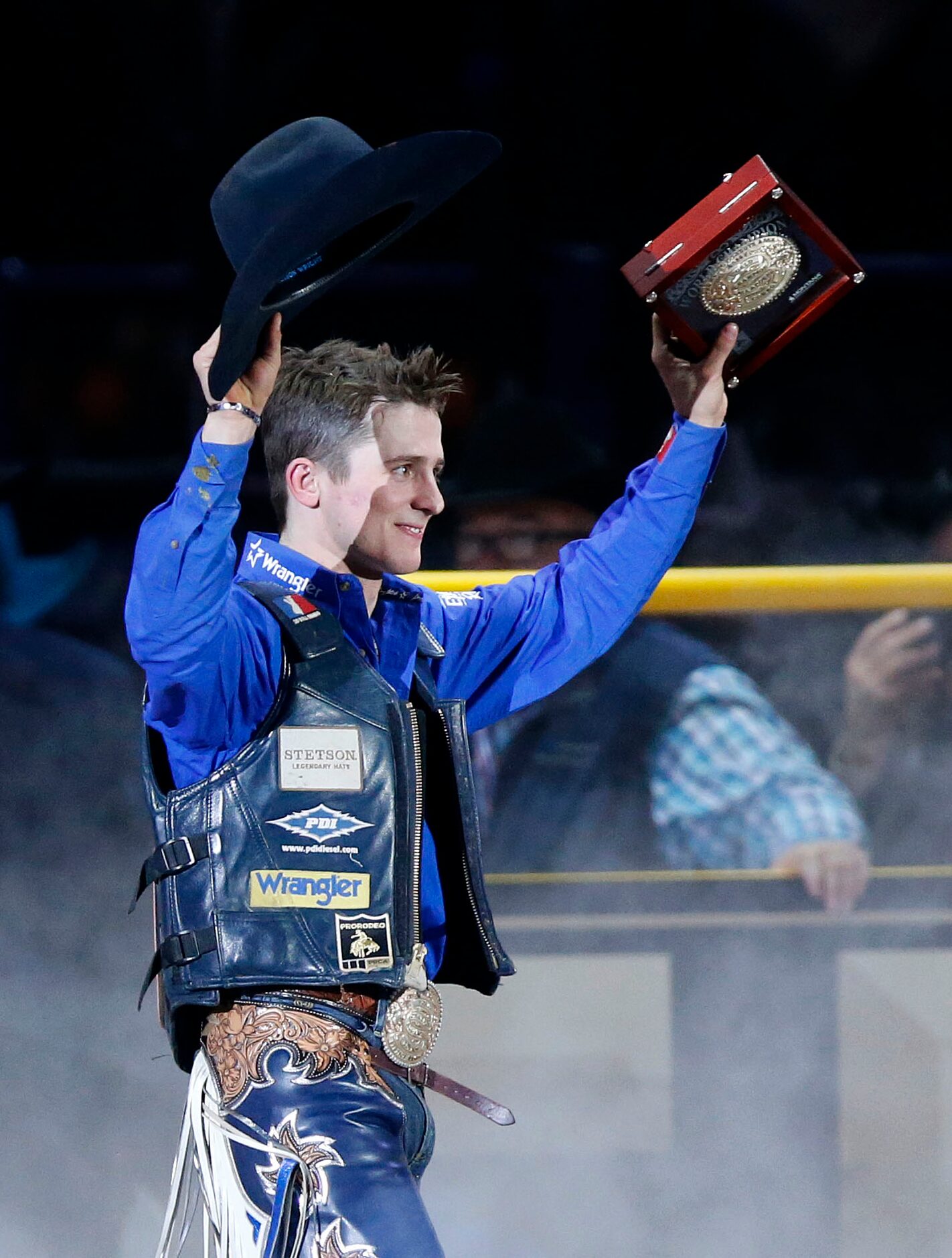 Bull Riding Champion Stetson Dell Wright of Milford, Utah raises his winning belt buckle...