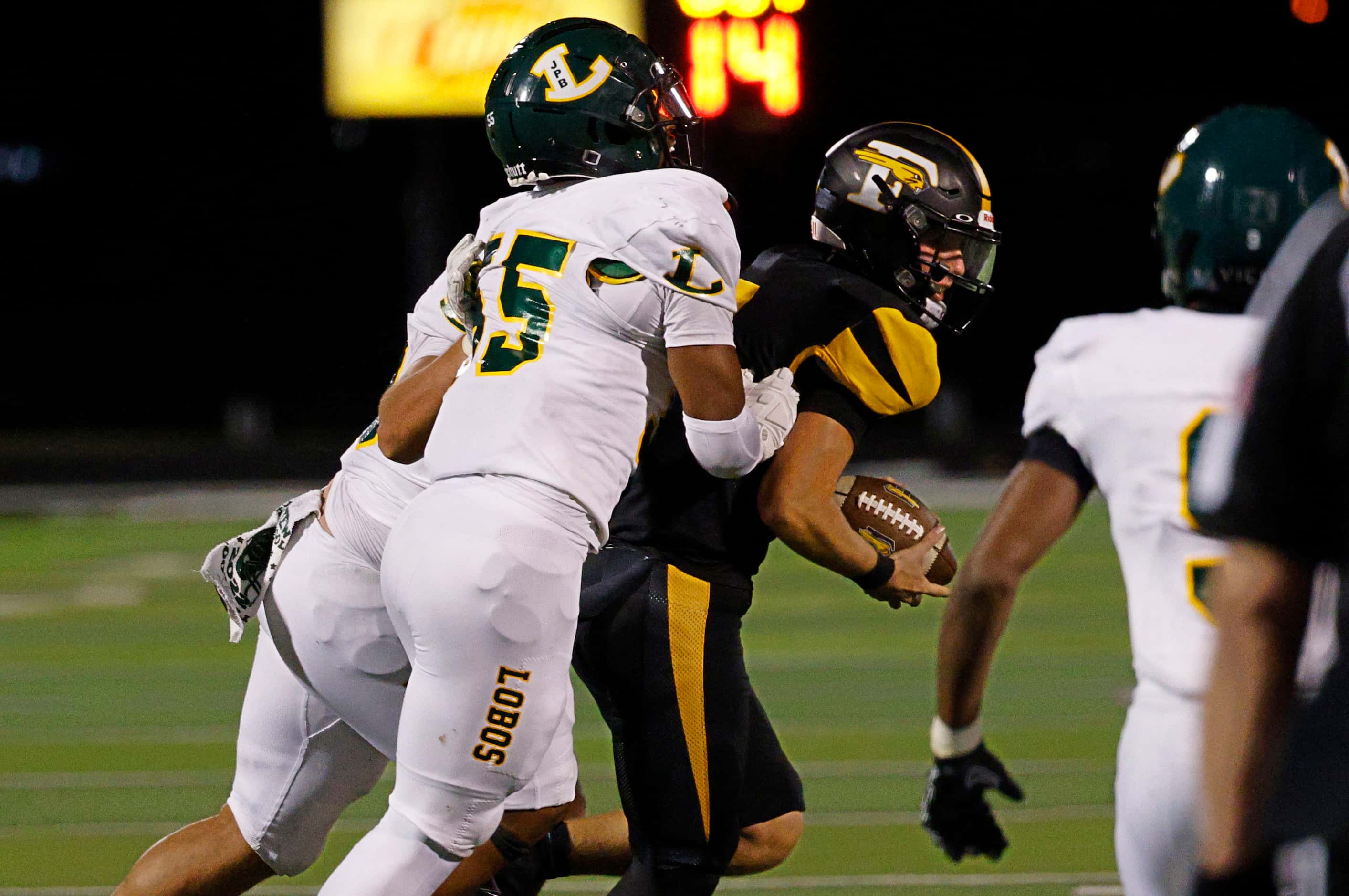 Forney's quarterback Kyle Crawford (3), right, is sacked by Longview's Xaryus Sheppard (55)...