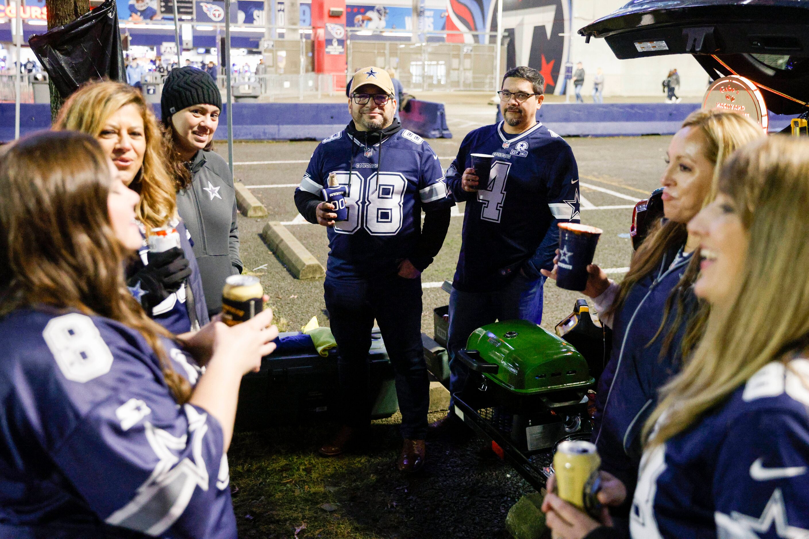 Dallas Cowboys fans Gabe Almanza (center left) and Deybi Aldana (center right) tailgate with...