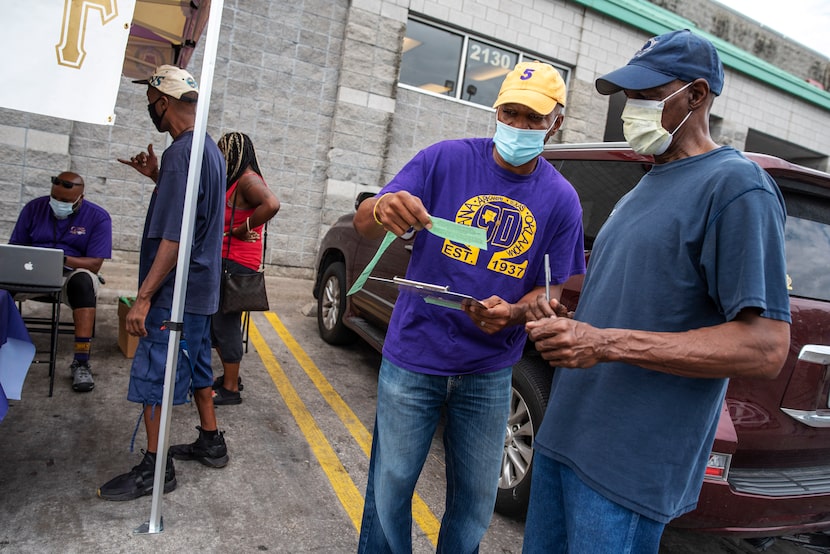 Nate Favaroth (center), a member of Omega Psi Phi fraternity, speaks to Ben Kennedy, 60, as...