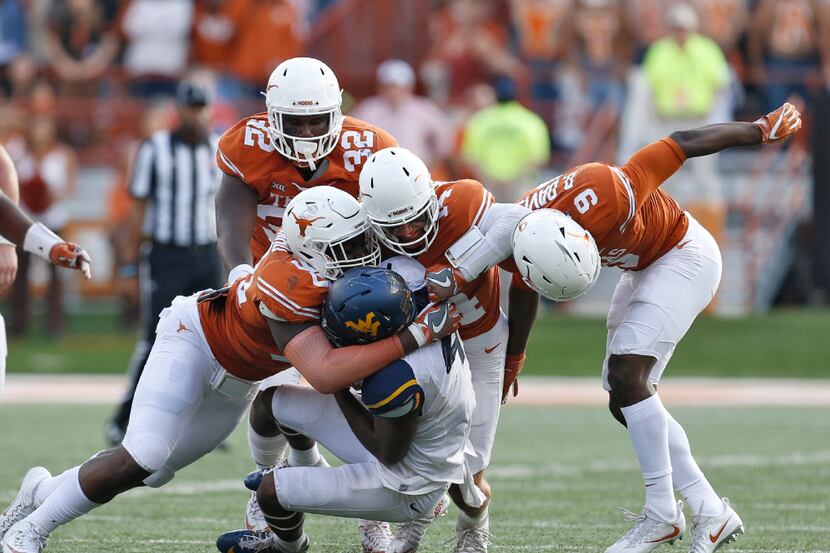 Texas Longhorns defensive end Charles Omenihu (90), safety Dylan Haines (14) and cornerback...