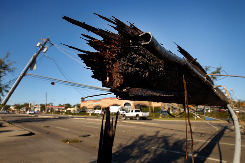A sheared off utility pole lays over Preston Road in Dallas, near the Preston Royal shopping...