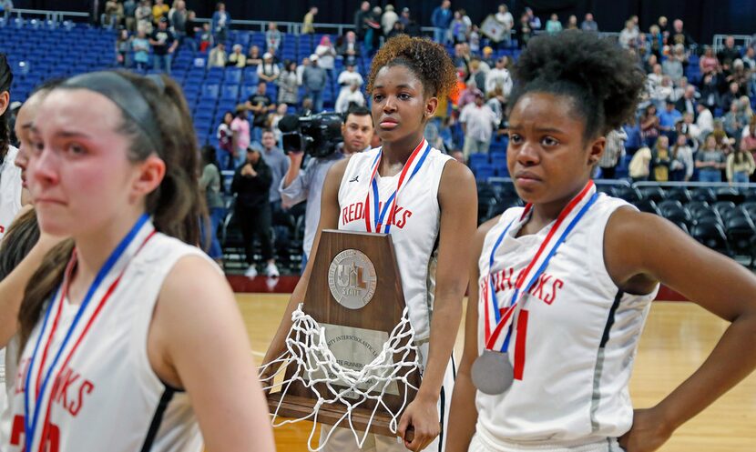 Libertyâs Randi Thompson walks off with their second place trophy after losing to...