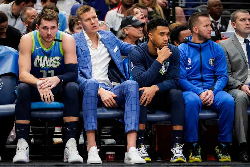 Dallas Mavericks guard Luka Doncic (left) and injured Kristaps Porzingis watch from the...