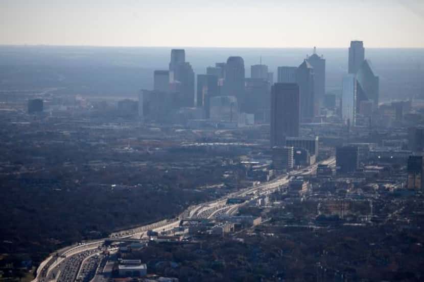 
The air hangs with haze as traffic moves Jan. 3 on Texas State Highway 75. CityPlace tower...