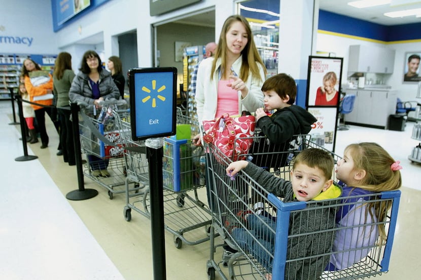 From left to right,  Amanda Wheat stands in line with her 2-year-old son Trevor Wheat,...