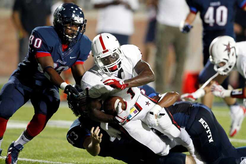 Coppell's Charles West is brought down by Allen's Camrin Manning (90), Luke McAllister (43)...