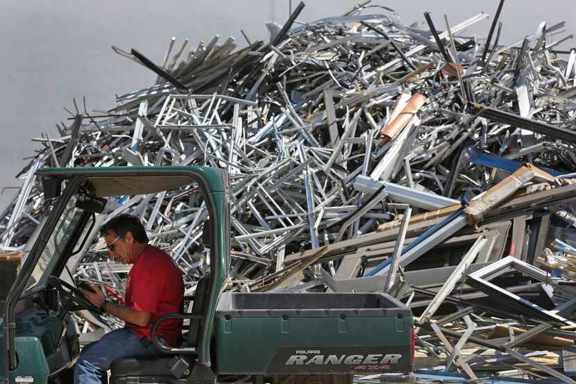 Dennis Laviage of C&D Scrap Metal Recyclers takes a phone call in front of a large pile of...