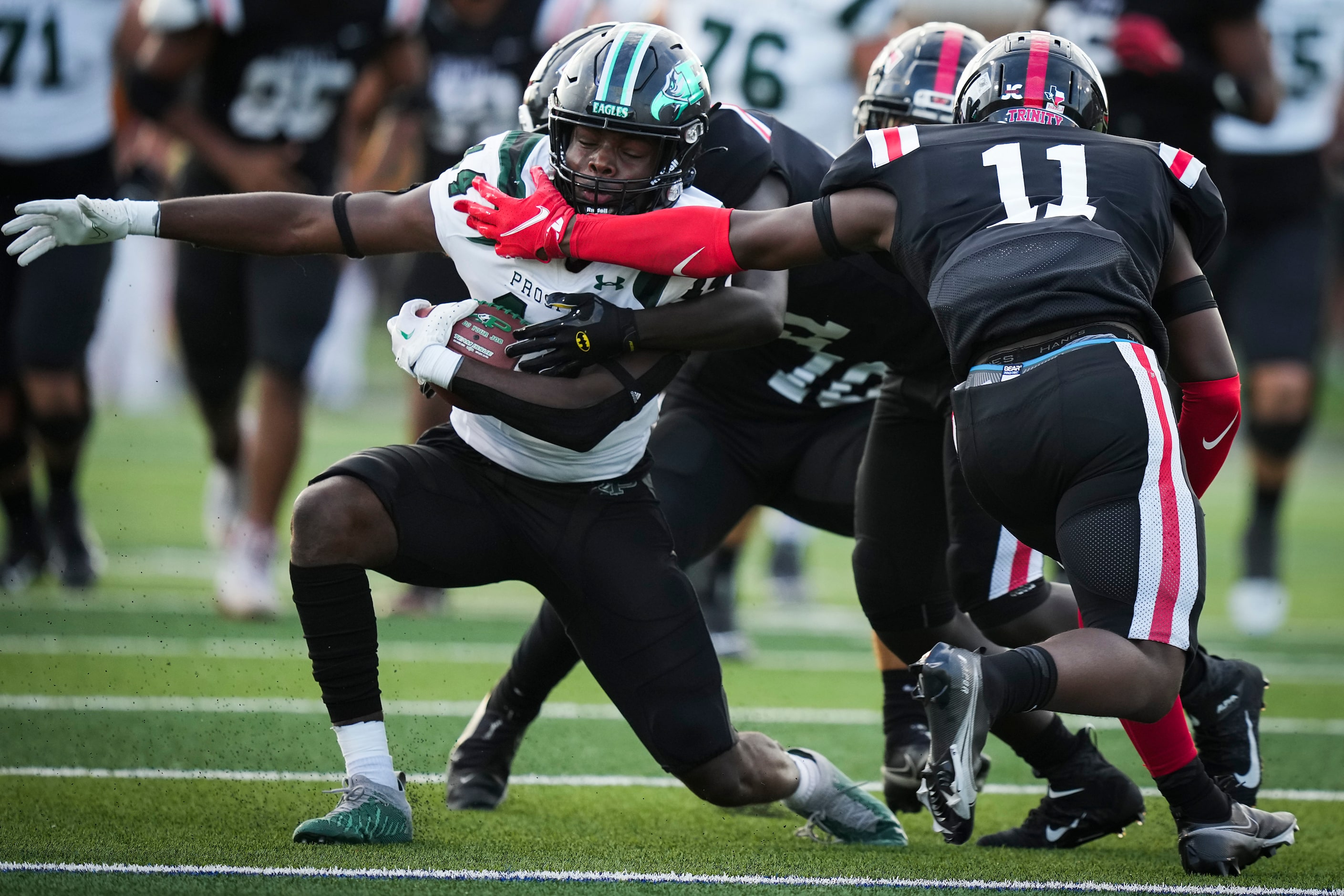 Prosper’s Javan Henry (14) is brught down by Euless Trinity’s Damarion Dean (4) and Javion...