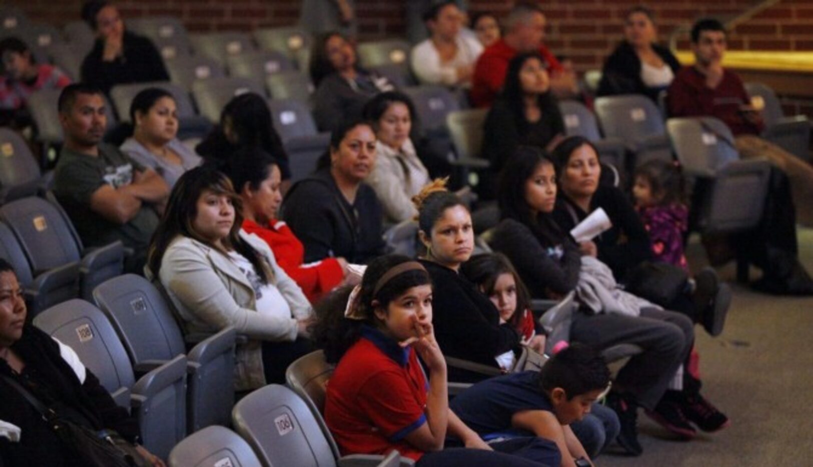 Un grupo de familias escuchan una charla informativa sobre DAPA y DACA, organizada por el...