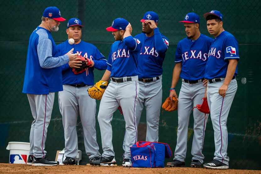 Texas Rangers pitching coach Doug Brocail (far left), talks with pitchers (from left)...