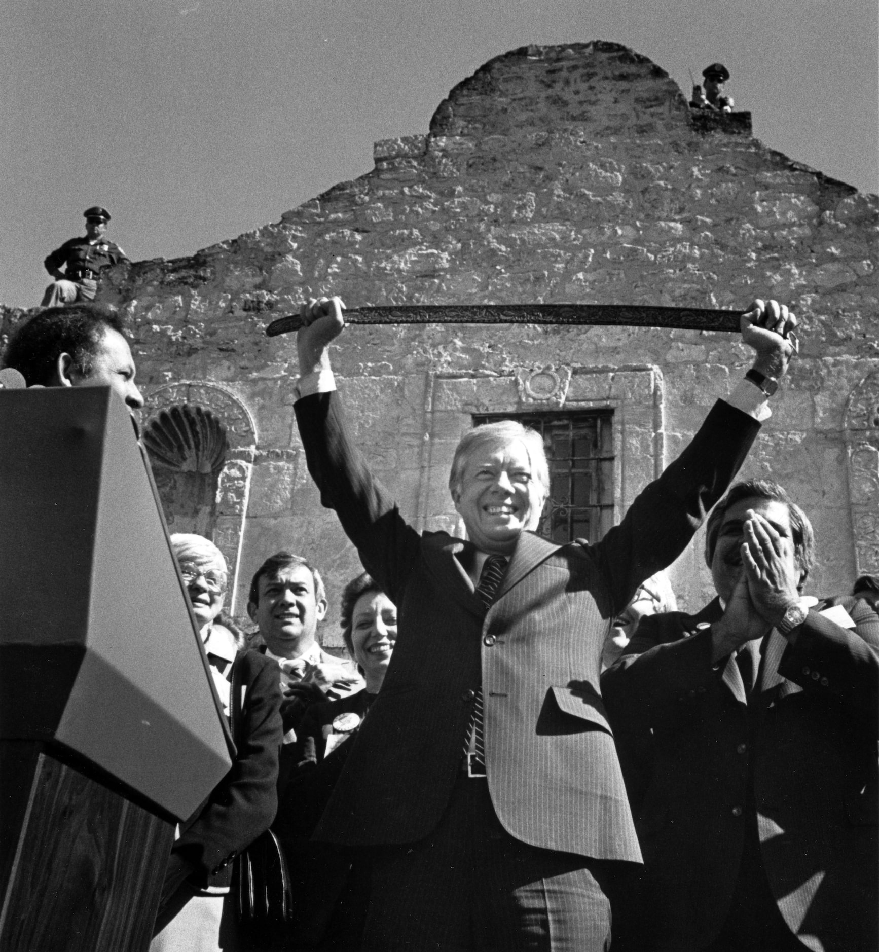 President Jimmy Carter holds up a carved belt given to him at the Alamo on Nov. 1, 1980, in...