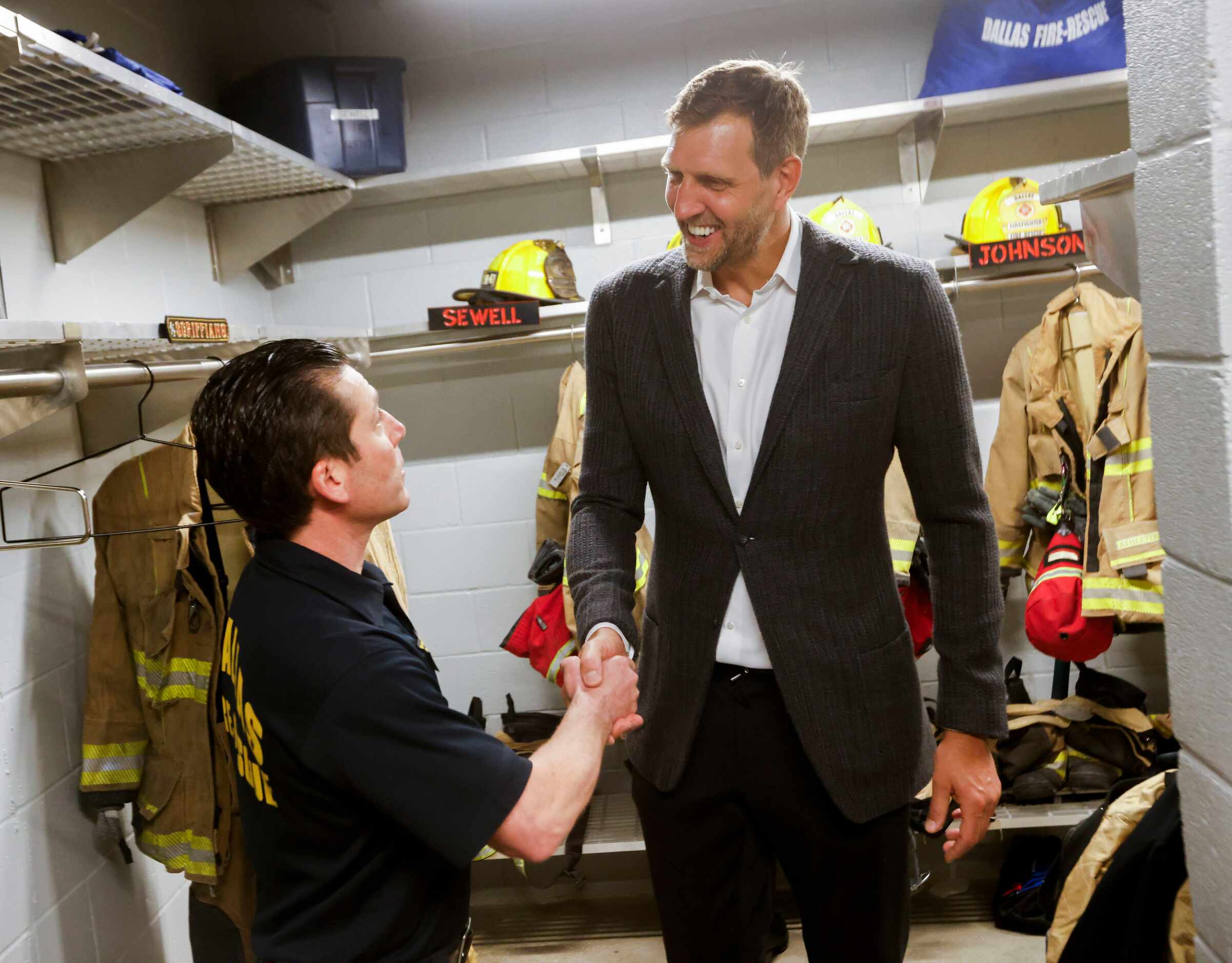 Driver engineer and paramedic Brad London (left) shakes hands with Dallas Mavericks Hall of...
