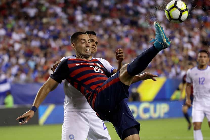 United States' Clint Dempsey (28) is defended by El Salvador's Henry Romero (4) during a...