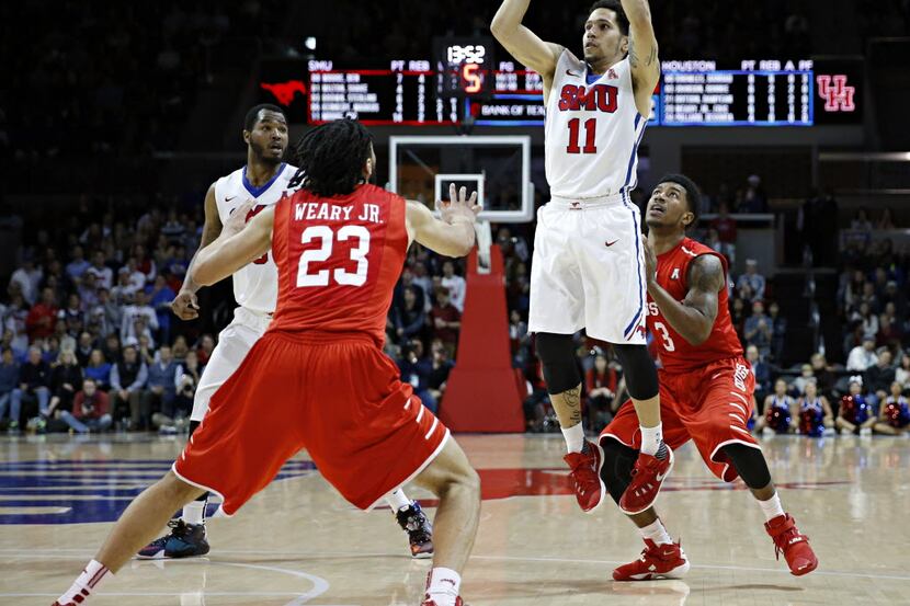 SMU guard Nic Moore (11) gets above Houston Cougars guard Ronnie Johnson (3) and guard Eric...