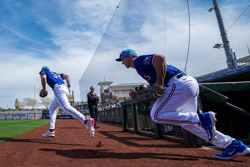 Texas Rangers outfielders Evan Carter (32) and Wyatt Langford take the field before their...