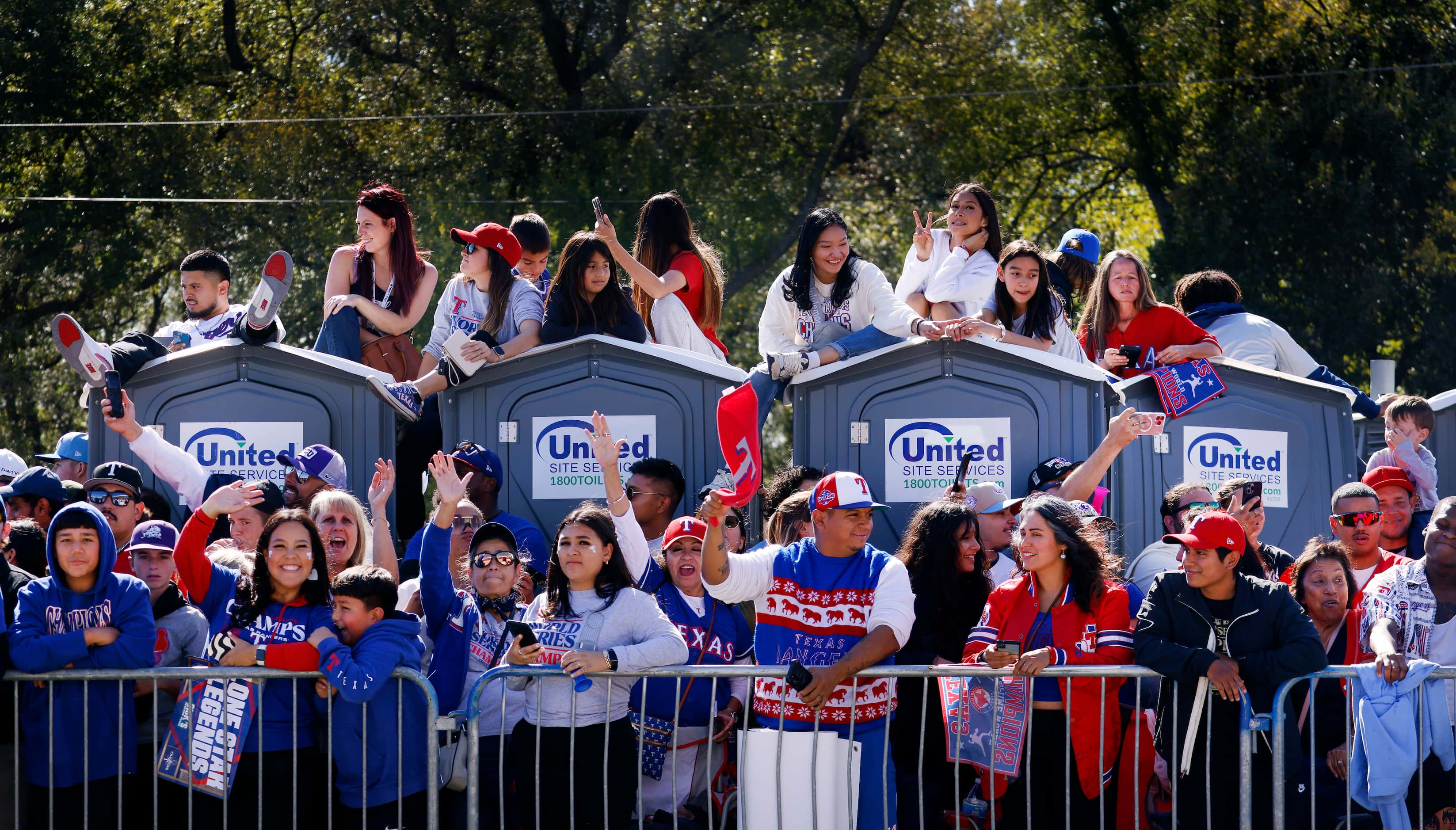Texas Rangers fans find a viewing spot atop portable toilets during the World Series Victory...