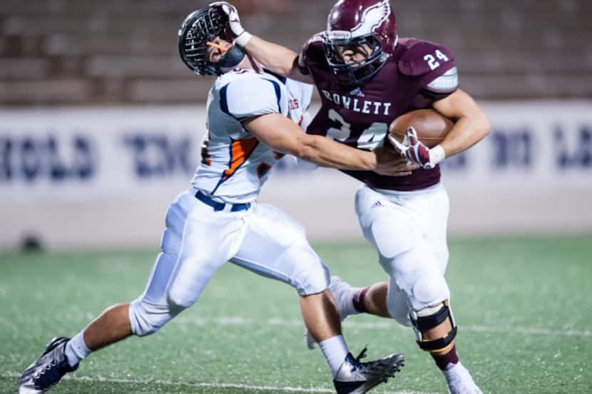 Rowlett running back Anthony Wagner blocks a Sachse athlete from grabbing the ball in last...