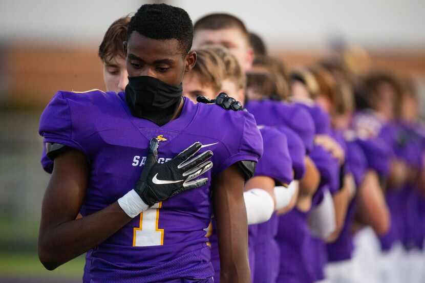 Sanger's Josh Henry wears a neck gaiter during the national anthem before the start of a...