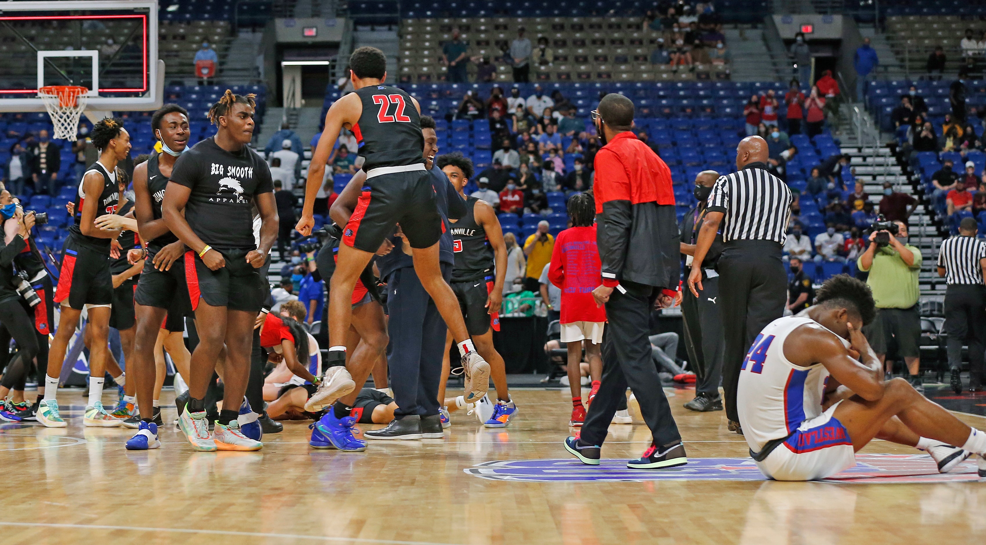 Westlake Kj Adams #24 sits on the floor as Duncanville celebrates their victory. UIL boys...