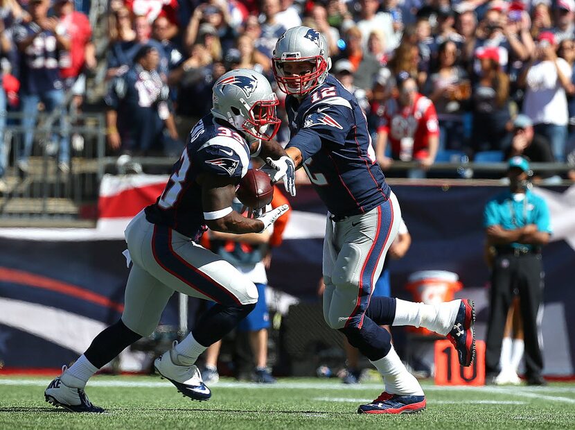 FOXBORO, MA - SEPTEMBER 27:  Tom Brady #12 of the New England Patriots hands the ball to...