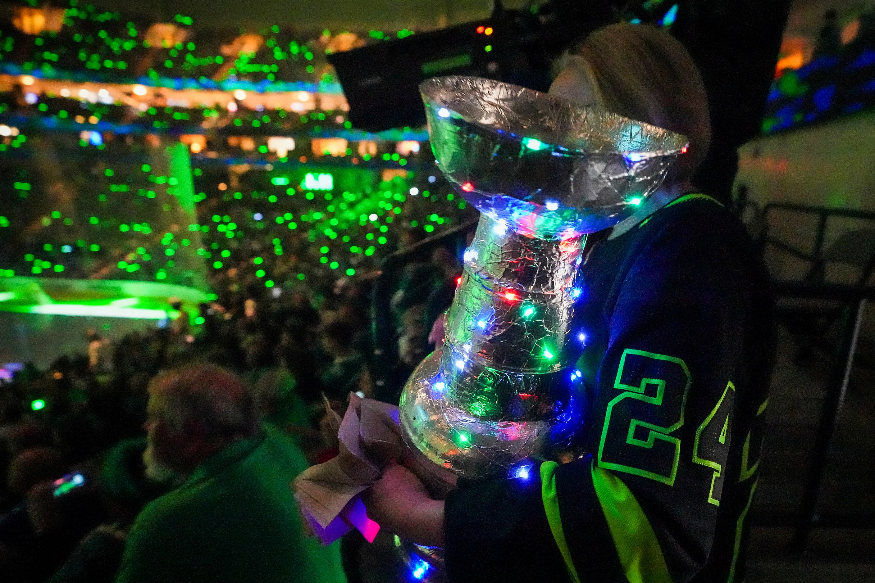 A Dallas Stars fan carries a Stanley Cup to her seat during a light show at the arena before...