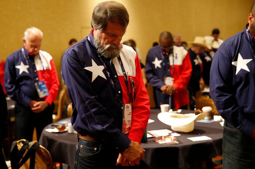 Texas delegate James Benson Ashby of Euless bows his head during prayer at the Texas...