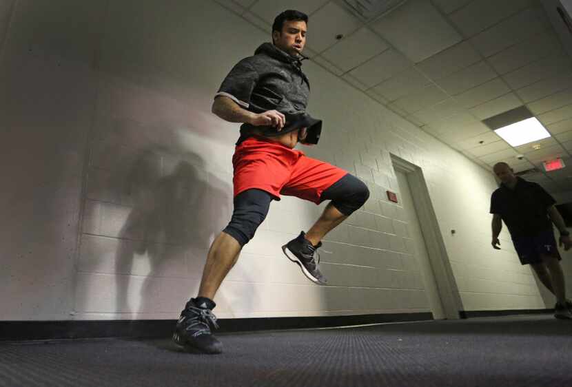 Texas Rangers relief pitcher Matt Bush works on his conditioning in a hallway by the indoor...