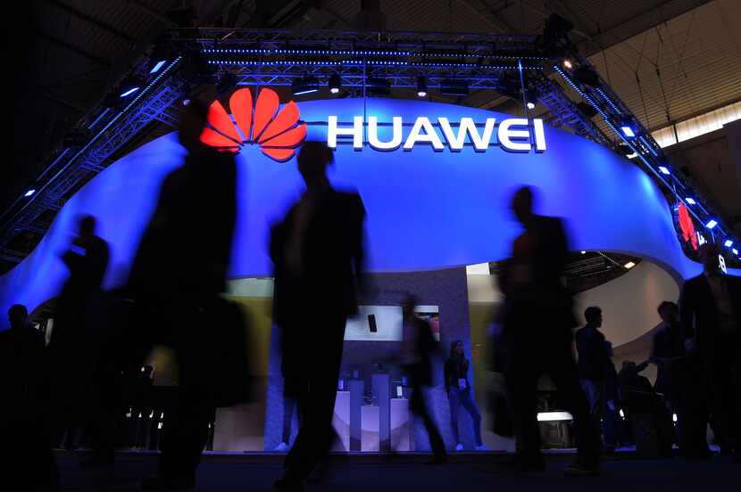 Visitors pass in front of the Huawei's stand on the first day of the Mobile World Congress...