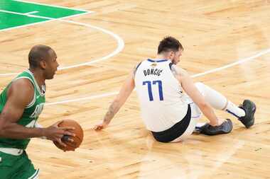 Dallas Mavericks guard Luka Doncic (77) grabs his ankle as Boston Celtics center Al Horford...