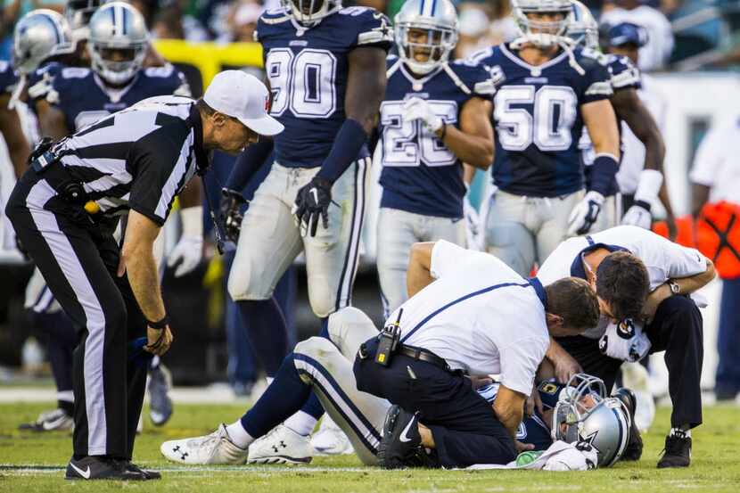 Dallas Cowboys quarterback Tony Romo (9) is checked out by trainers after an injury during...