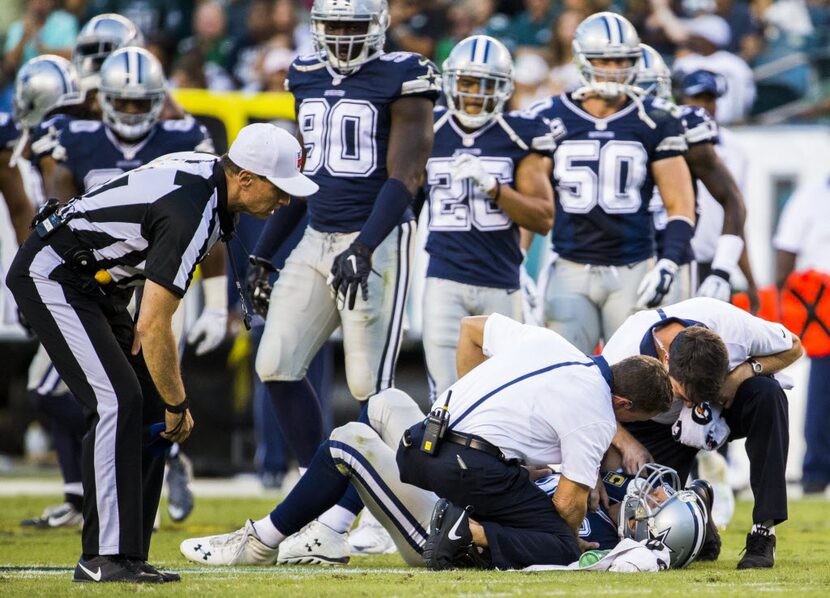 Dallas Cowboys quarterback Tony Romo (9) is checked out by trainers after an injury during...