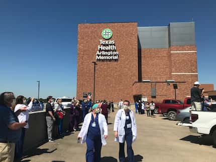 Hospital employees gather on the roof of the parking garage at Texas Health Arlington...