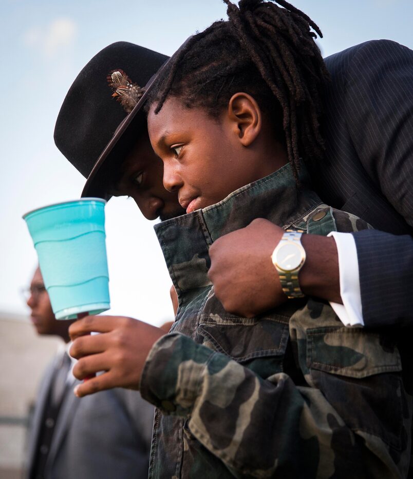 Dr. Michael W. Waters hugs his son Jeremiah during the "Remember His Name: Vigil for Jordan...