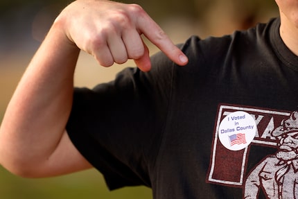 Woodrow Wilson senior Jake Berend, 18, pointed to his voted sticker after doing so with...