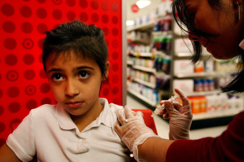 Skylar Lima, 7 gets a flu shot  from Target Pharmacist Claudia Torres at the Montfort...