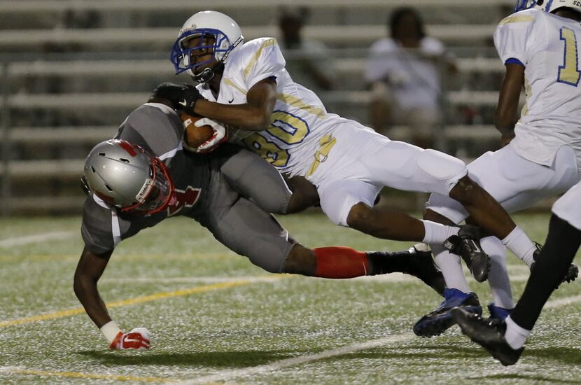 TXHSFB Conrad senior defensive back Antonio Bivins (80) tackles Woodrow Wilson junior...