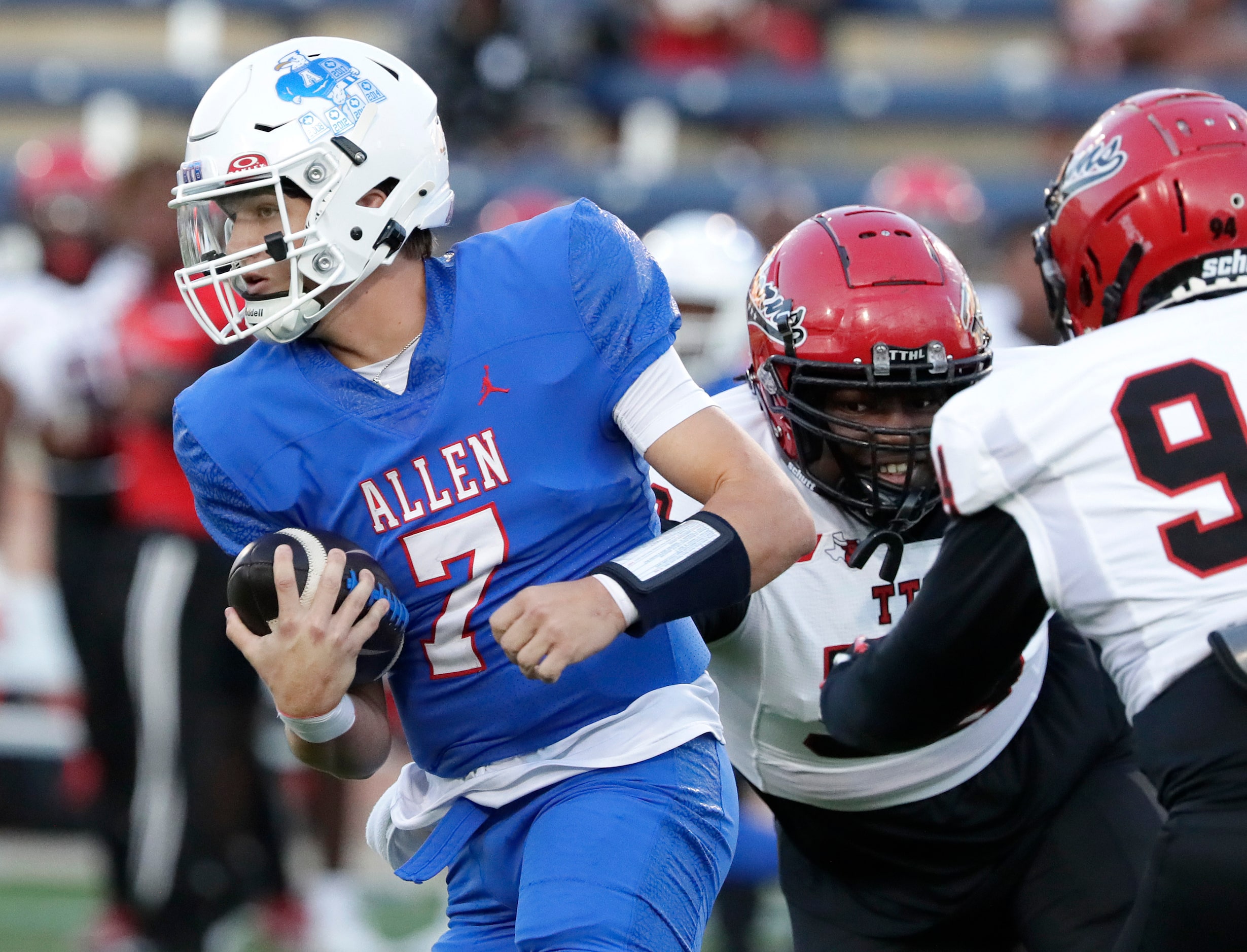 Allen High School quarterback Brady Bricker (7) escapes Cedar Hill High School defensive...