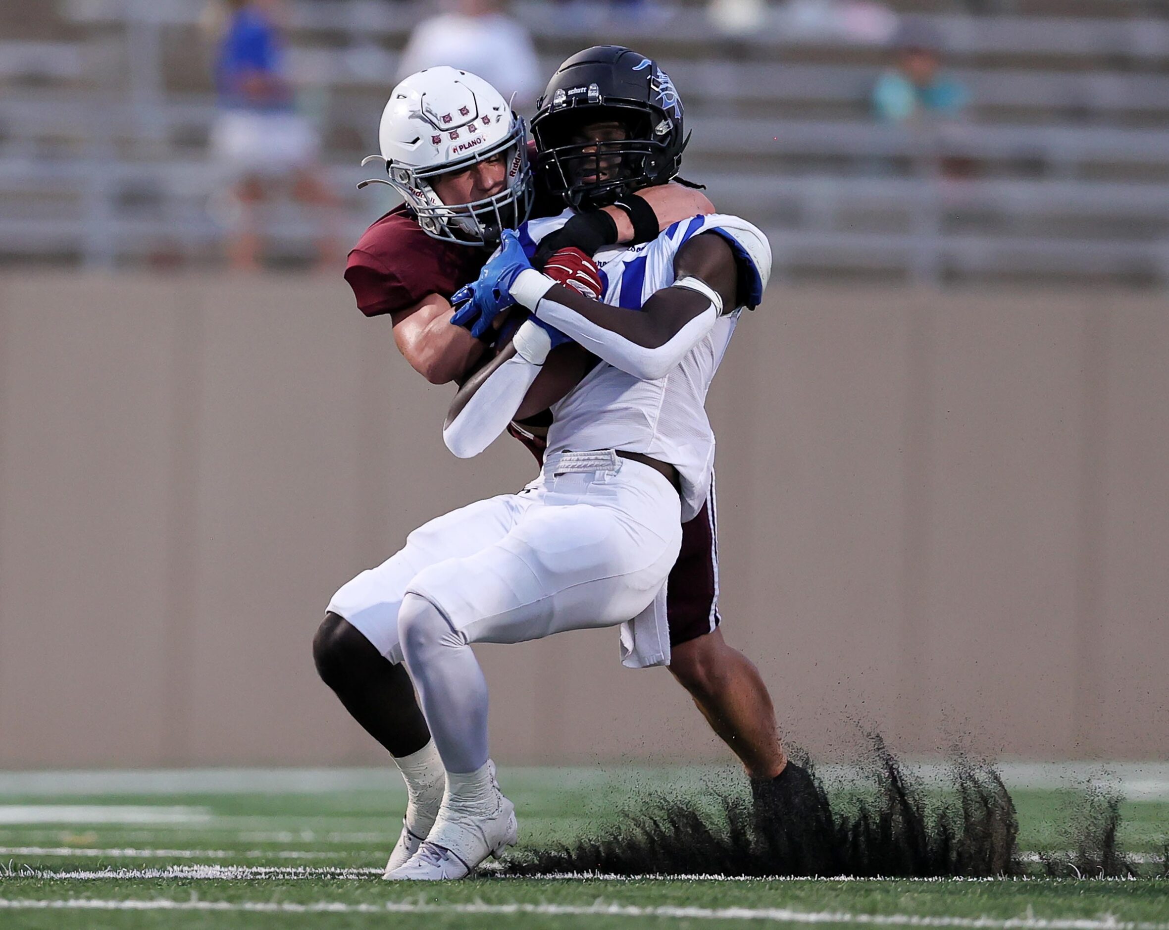 Byron Nelson running back Manny Mulumba, (center) gets pulled down by Plano linebacker...