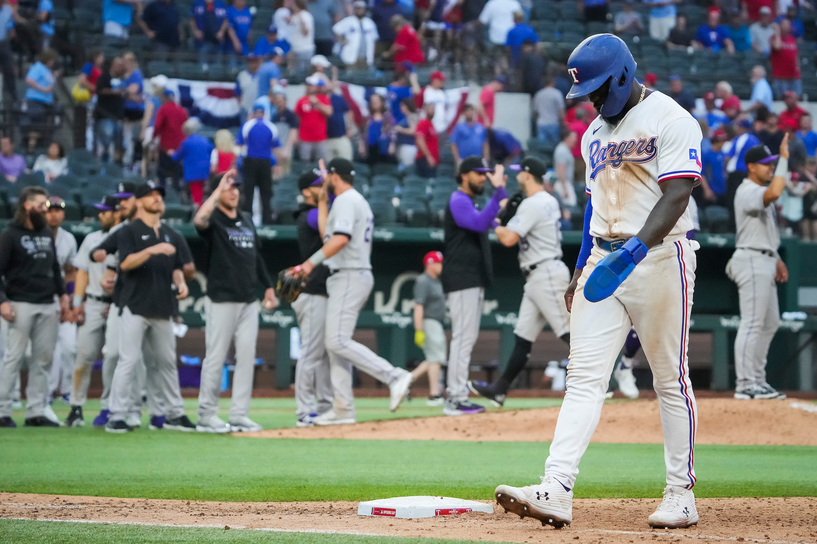 Texas Rangers center fielder Adolis Garcia walks off the field as Colorado Rockies players...