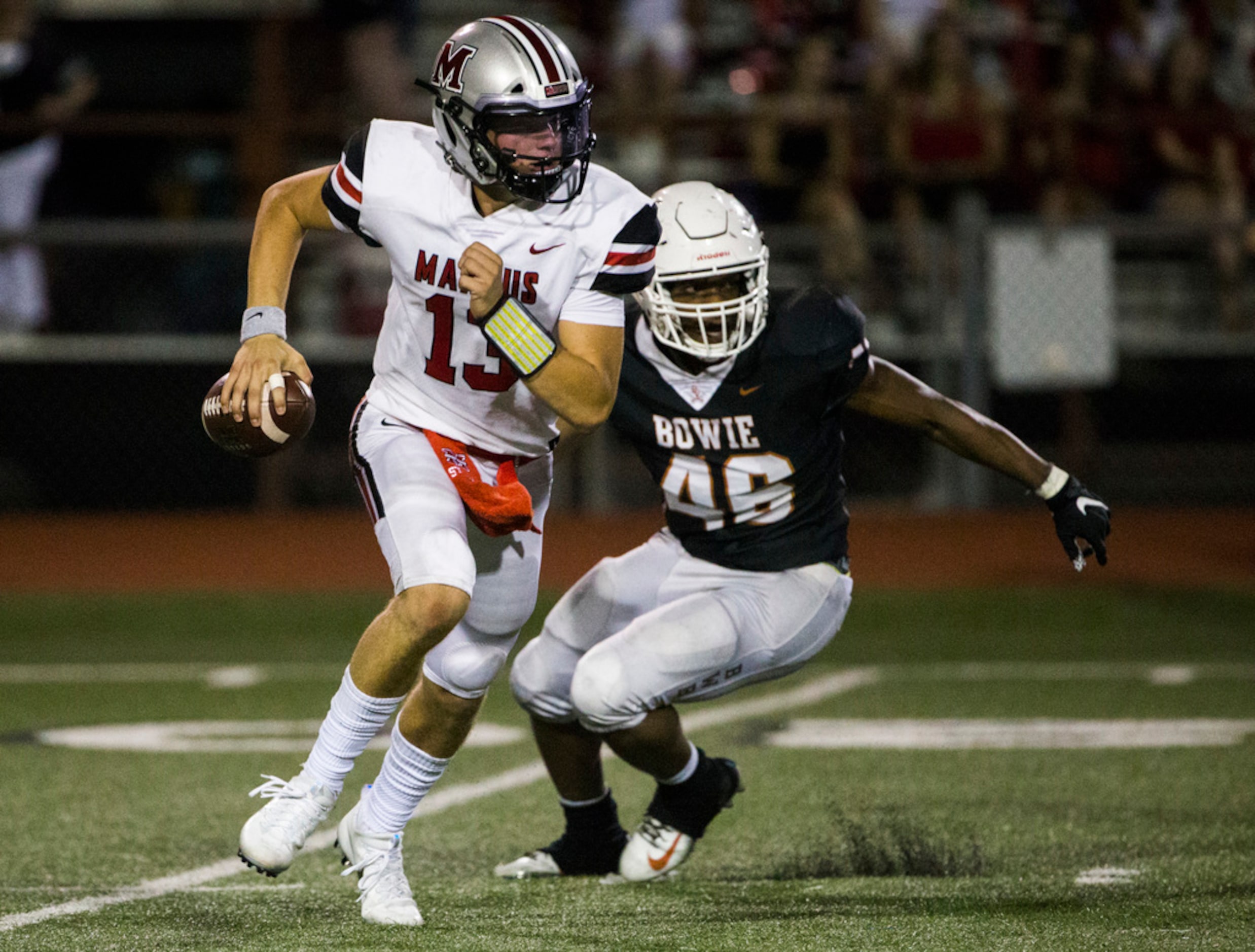 Flower Mound Marcus quarterback Garrett Nussmeier (13) is threatened by Arlington Bowie...