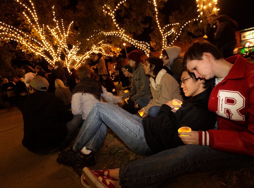 Reyna Cox (left) and Evan Adams hold candles during a Transgender Day of Remembrance event...