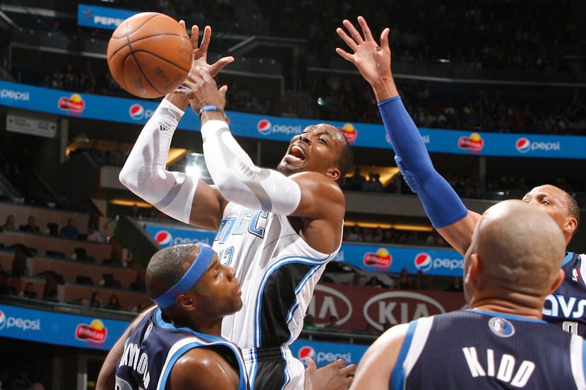 Orlando center Dwight Howard is hit by Dallas' Brendan Haywood (lower left) during the first...