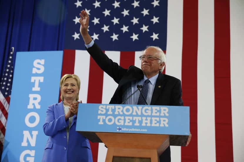 Sen. Bernie Sanders, I-Vt. waves as he a Democratic presidential candidate Hillary Clinton...