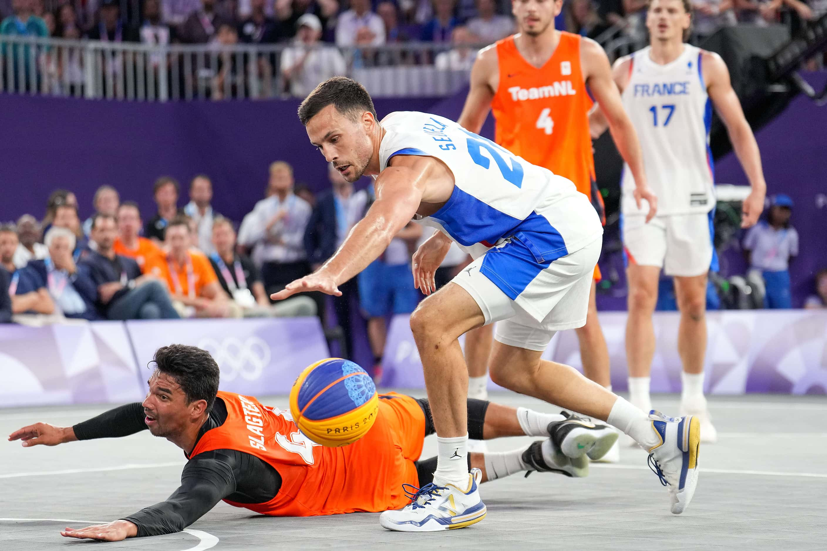 Arvin Slagter (44) of the Netherlands dives for a loose ball against Franck Seguela (21) of...