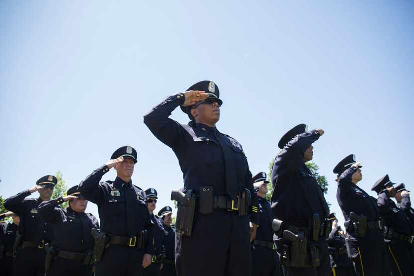 Texas law enforcement officers saluted as names of Texans are read during a roll call of...