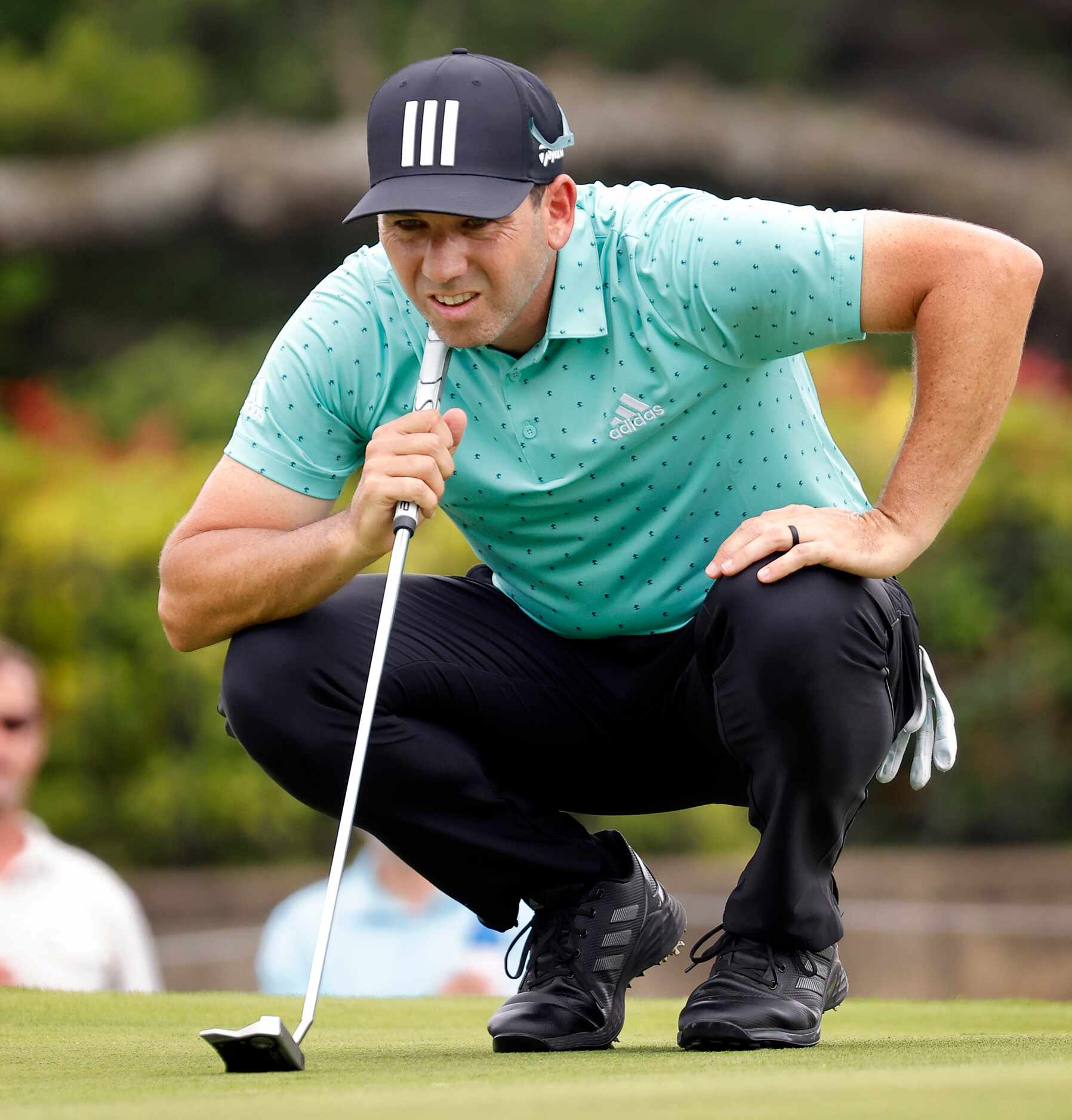 Professional golfer Sergio Garcialinesup his putt on No. 17 during round one of the Charles...