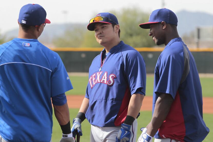 Texas Rangers outfielder Shin-Soo Choo talks with teammates Leonys Martin, left, and...