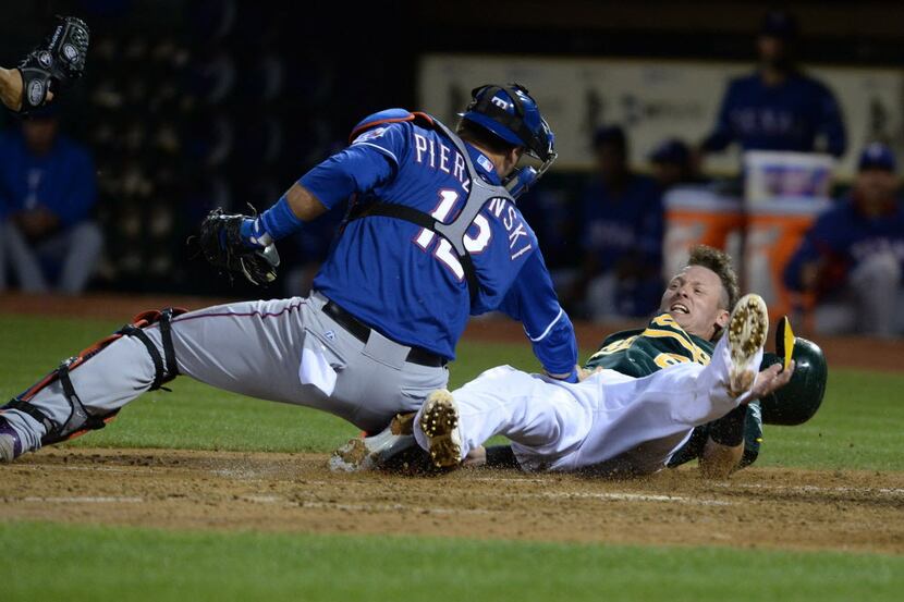 Oakland Athletics' Josh Donaldson (20) is tagged out at home by Texas Rangers' A.J....