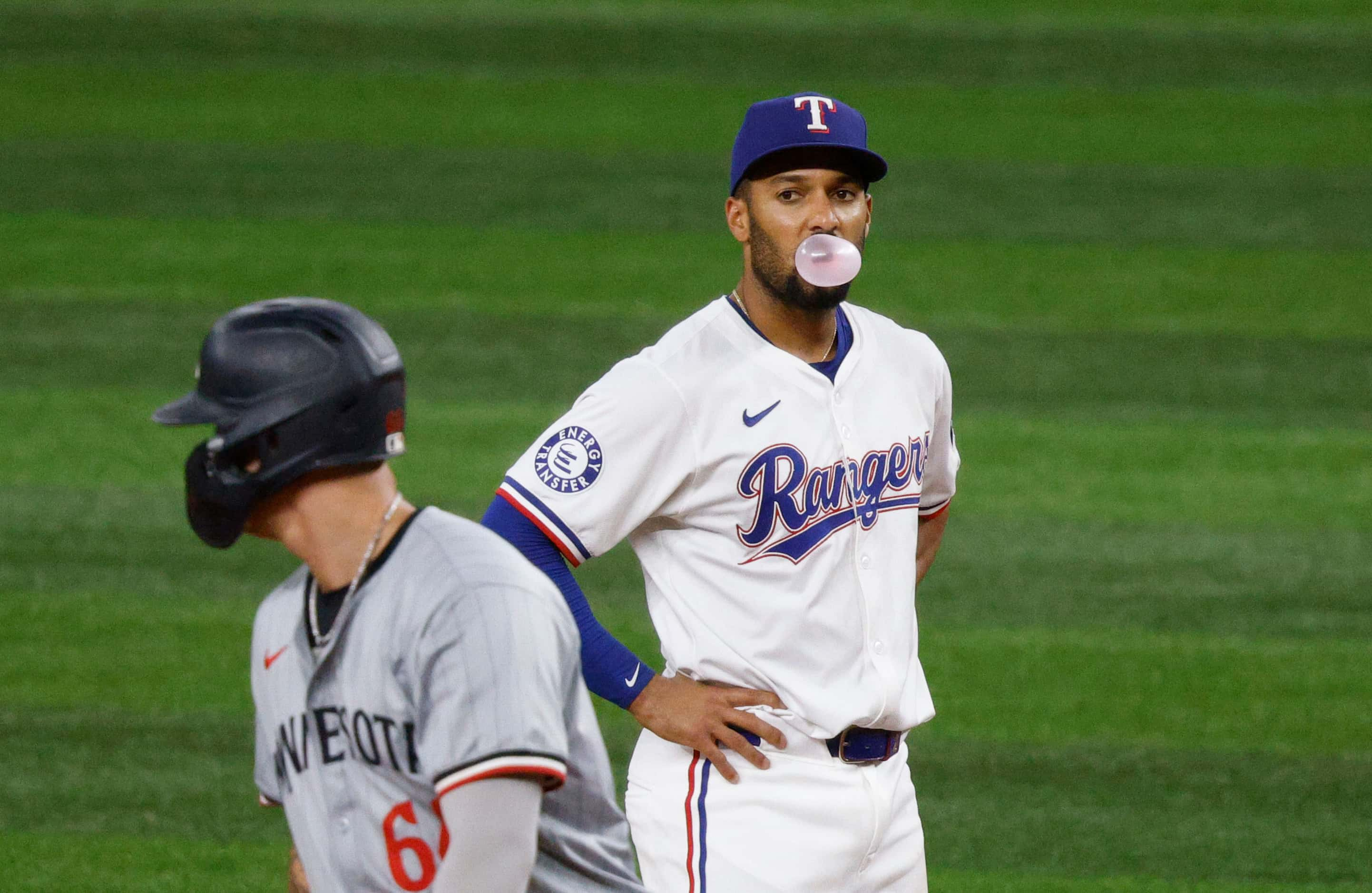 Texas Rangers second base Marcus Semien (2), right, blows a bubble gum as he watches...